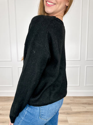 Black knit long-sleeve sweater, side view, crew neck