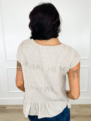Heathered taupe short-sleeve peplum top with ruched back and tiered ruffle hem