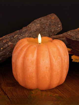 Orange pumpkin LED candle with glowing white wick flame