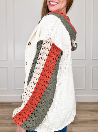 Cream knit cardigan with hood, long sleeves, patchwork red/gray stripe detail