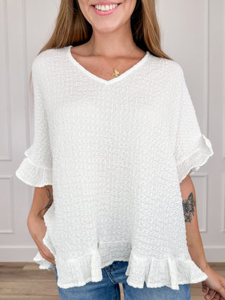 Lightweight short sleeve V-neck top in white with layered ruffle cuffs and hem