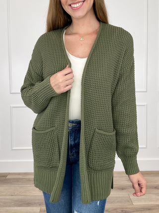 Olive green knit long-sleeve cardigan with open front and ribbed hem and cuffs