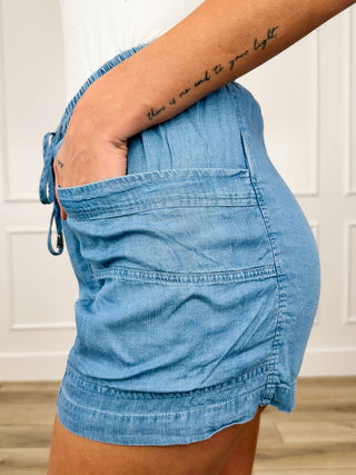 Light wash denim high-rise shorts, side view with belt loops and drawstring closure