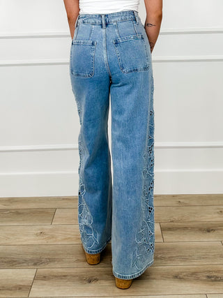Light wash high-rise wide-leg jeans with embroidered lace details on hems