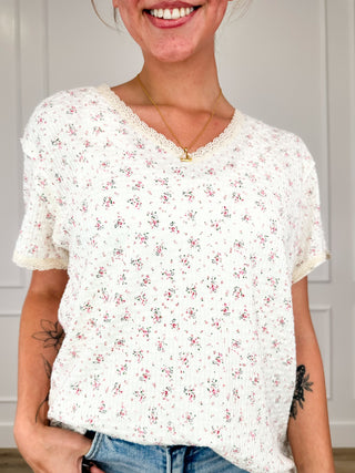 Ivory ribbed short-sleeve top with small floral print, scoop neck and button detail