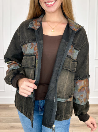 Black cropped denim jacket with floral contrast sleeves, zip front, and chest pockets