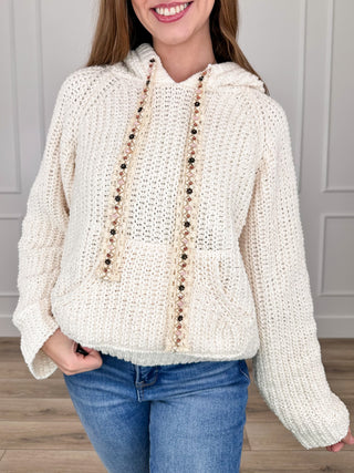 Cream hooded knit sweater top with long sleeves and buttoned front placket
