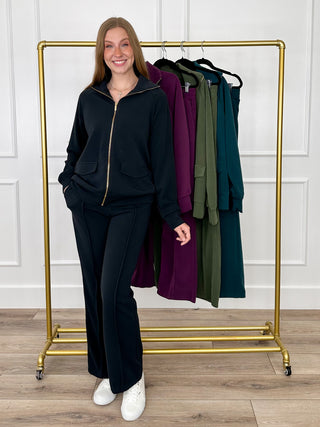 Black zip-up hoodie and matching pants two-piece set on model