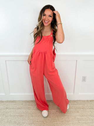 Coral sleeveless jumpsuit with buttoned chest and wide-leg silhouette
