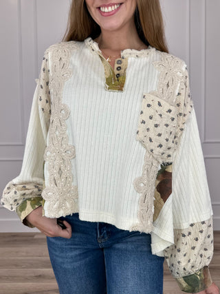 Ivory long-sleeve cropped top with henley button placket and dotted floral lace panels