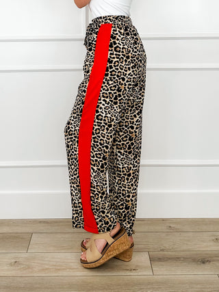 Leopard print high-rise pants with bold red side stripe, rear view