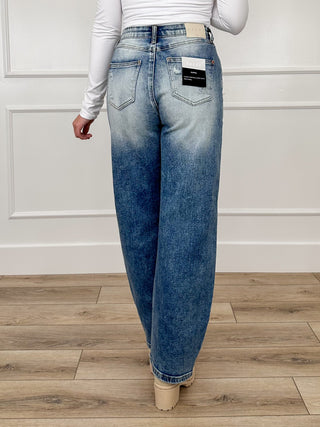 Medium-wash barrel-leg jeans with dark wash back paneling and logo patch at waist