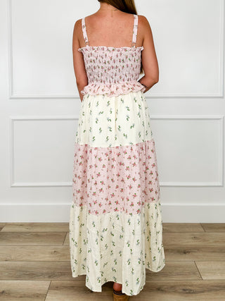 Back view of pink and cream tiered maxi dress with spaghetti straps