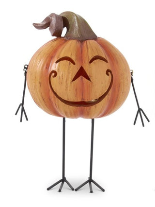 Resin jack-o'-lantern decor with wide grin face, standing on black tripod legs
