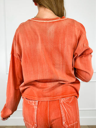 Rust orange cotton long-sleeve top with crew neck, back view