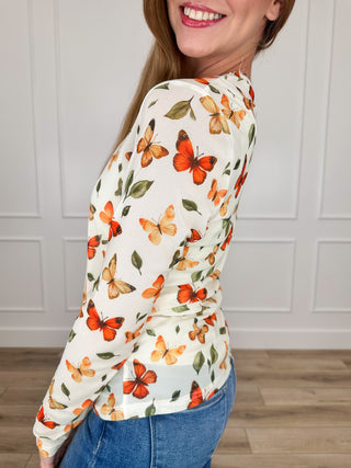 Cream sheer mesh long-sleeve top with orange and green butterfly floral print