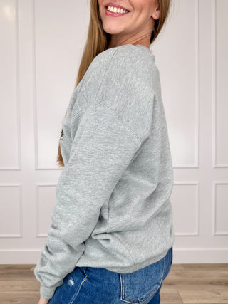 Grey crewneck sweatshirt with long sleeves, side view on model