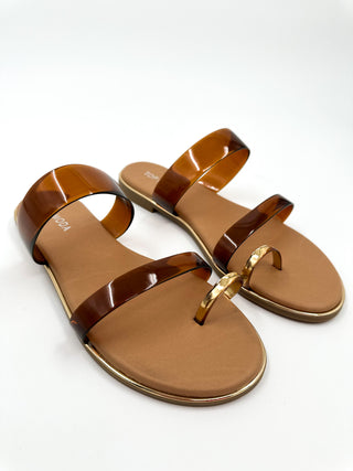 Tan flat sandals with two wide straps and gold-tone ring buckle