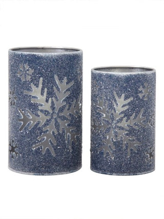 Pair of speckled blue metal candle holders with large snowflake cutout pattern.
