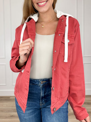 Brick red hooded denim jacket with long sleeves, front buttons, and white drawstring