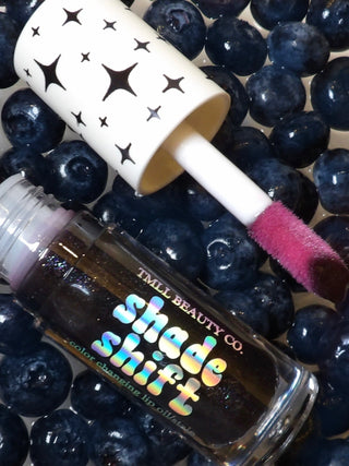 Mood lip oil with iridescent label and wand applicator with pink-tinted tip