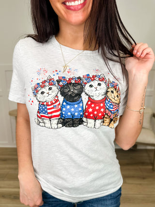 Light gray short-sleeve graphic tee with patriotic cats in a row across chest