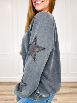 Grey long-sleeve crewneck sweatshirt with distressed star patch on sleeve and hem