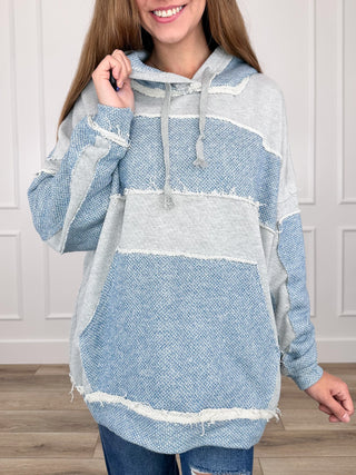 Blue knit hoodie sweatshirt with hood, drawstring, and kangaroo pocket, striped panel design