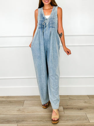 Light wash denim jumpsuit with gathered bib, sleeveless wide-leg design and tie neckline
