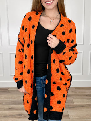 Reversible long-sleeve knit cardigan, orange with black dot pattern, open front