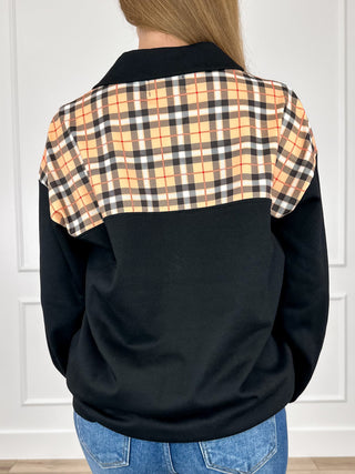 Black quarter-zip pullover back with orange plaid yoke panels and stand collar