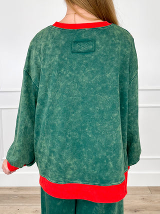 Green cotton long-sleeve top with red neck trim and small patch on back