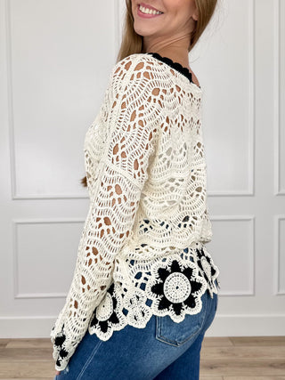 Cream crochet knit long-sleeve sweater with black flower motif hem and cuffs