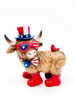 Plush cow figurine with patriotic top hat, red boots, holding small bird