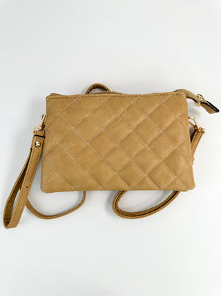 Tan quilted faux-leather crossbody bag with zip top and adjustable shoulder strap