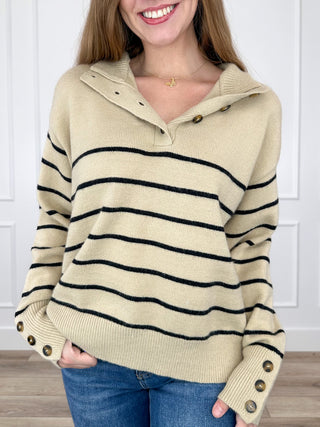Tan knit long-sleeve sweater with hood, navy stripe bands, buttoned cuffs