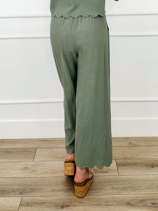 Green high-rise wide-leg pants with scalloped hem detail and relaxed fit
