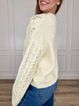 Cream knit cropped sweater with long sleeves and cable texture