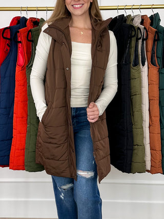 Brown sleeveless puffer vest with hood, front button placket and side pockets