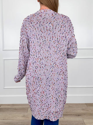Knit long-sleeve cardigan back view, speckled purple-pink-white knit