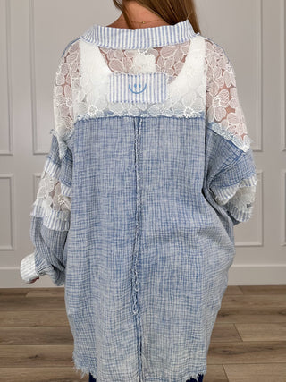 Blue cotton long sleeve top with lace yoke and ruffled, frayed hem