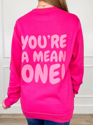 Pink crewneck sweatshirt with large "YOU'RE A MEAN ONE" graphic on the back.