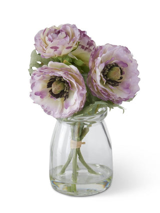 Lavender flower bouquet in clear glass vase with green leaves