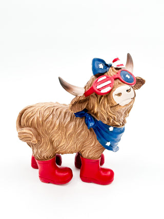 Plush cow figurine in blue scarf with patriotic top hat and red boots