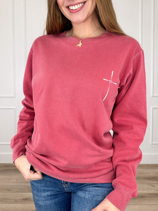 Brick red crewneck sweatshirt, long sleeves, small chest cross graphic
