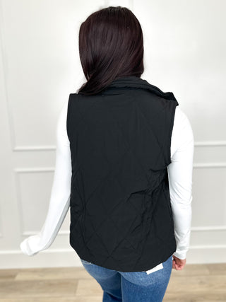 Black puffer vest back view with quilted panels and snap closures