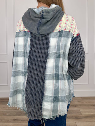 Charcoal hooded long-sleeve top with multicolor stripes and plaid panels, back view