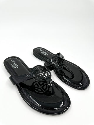 Black thong sandals with glossy finish and caged knot cutout buckle strap