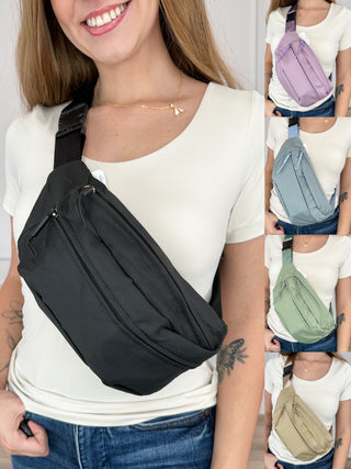 Black belt bag with front zip pocket and adjustable strap, worn across the chest