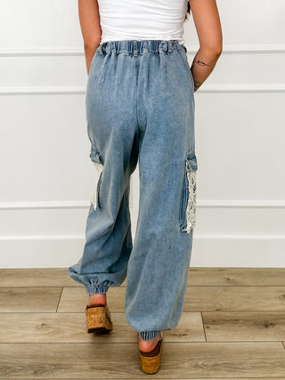 Back view light denim blue cargo joggers with drawstring waist and patch cargo pockets.